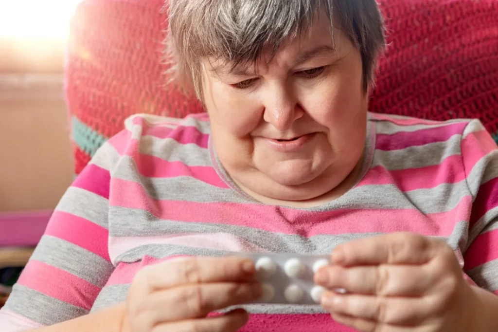 Disabled woman looking at medication