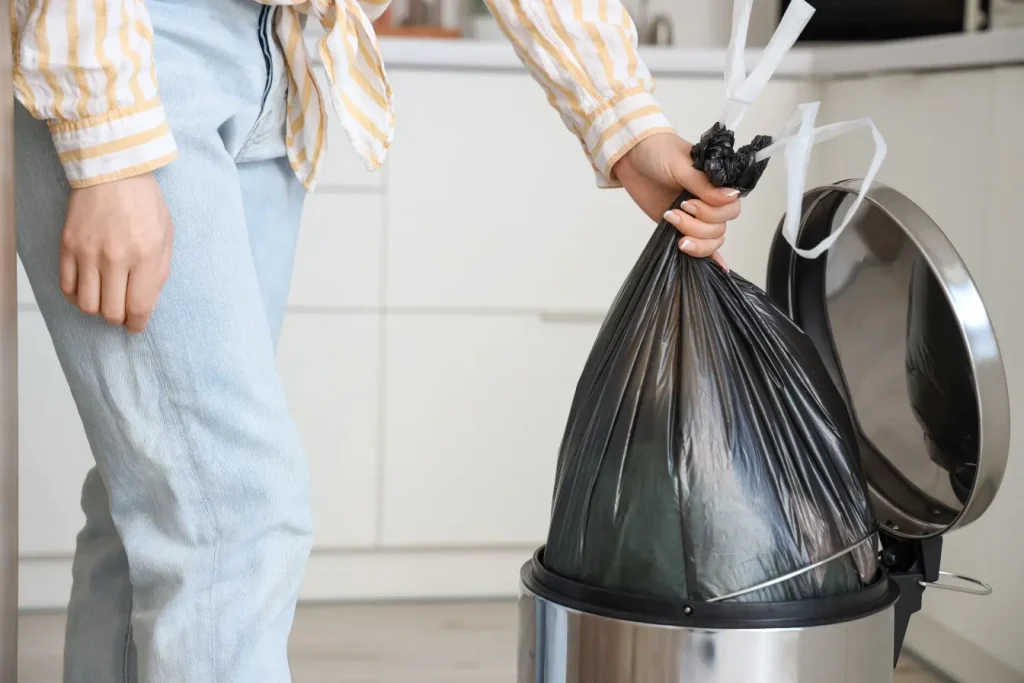 Close up of woman taking rubbish out of bin