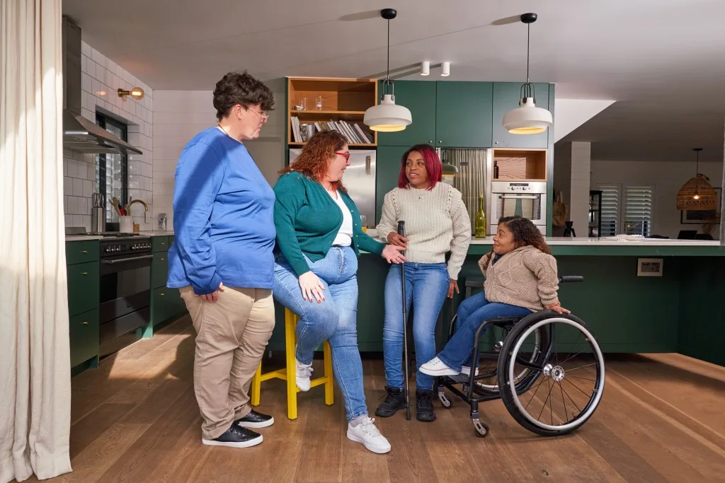Diverse friends in kitchen at home talking