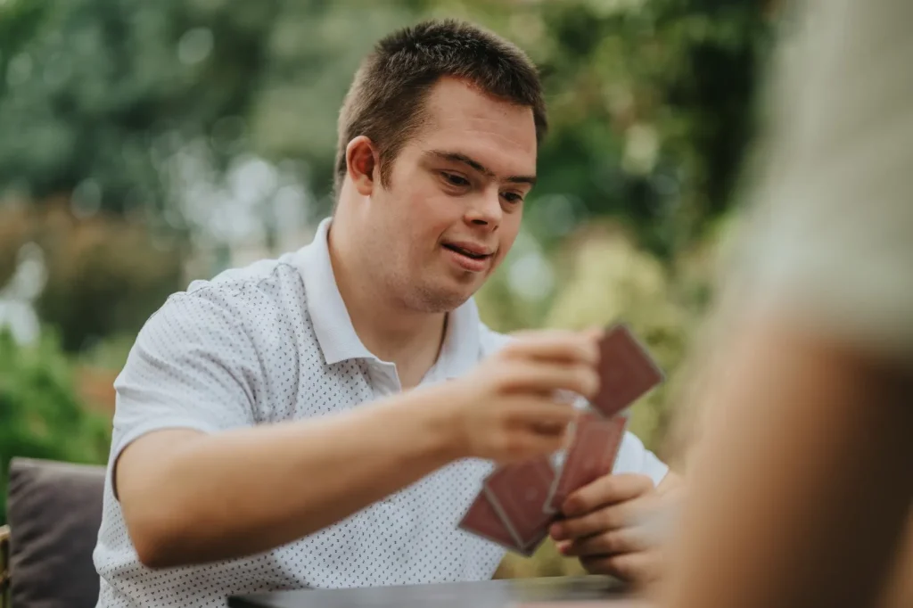 Disabled man playing card game with friend