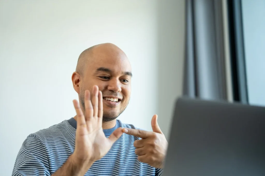 Deaf man communicating via sign language on video call