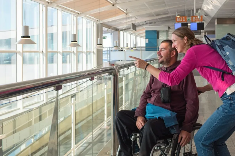 Disabled man with support worker at airport